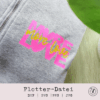 Plotterdatei MORE LOVE – pinker und grüner Schriftzug auf grauem Stoff, angebracht mit Bügelfolie, als DIY-Beispiel für Shirts oder Taschen, perfekt für Valentinstag, Hochzeit oder Geschenkideen.