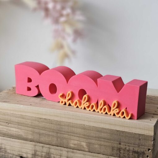 3D-gedruckter Schriftzug Boom Shakalaka in Pink und Orange auf Holzblock – DIY-Deko aus STL- und 3MF-Datei von The Vectorians